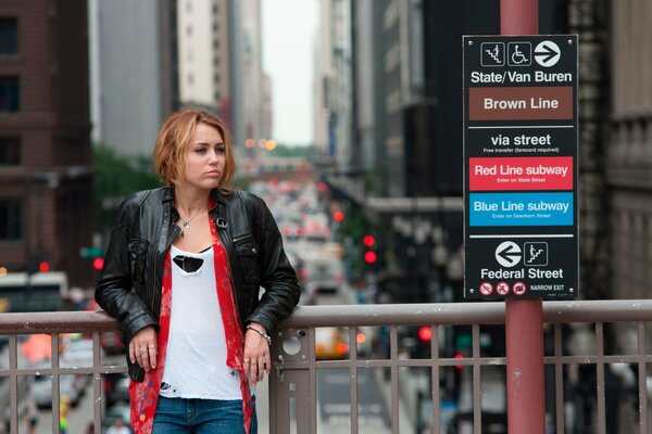 Jeune fille dans une veste en cuir se tient sur le pont