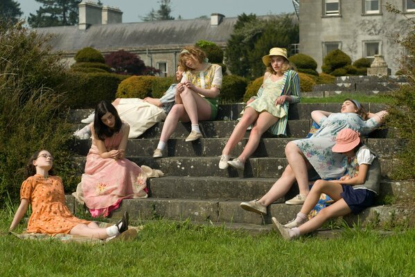 Girl friends are sitting on a stone staircase