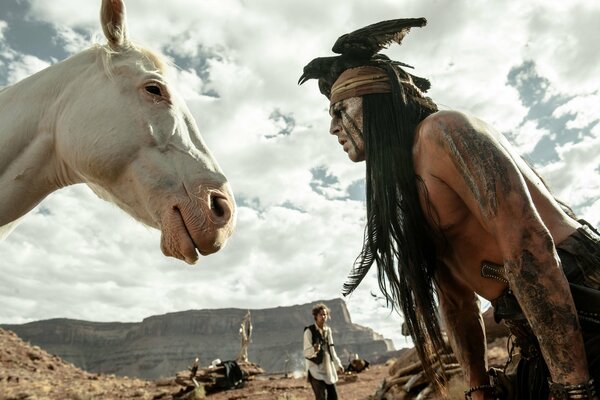 An Indian in front of a horse in profile