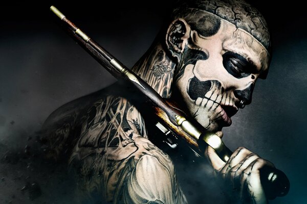 Guy freak avec un pistolet dans les tatouages