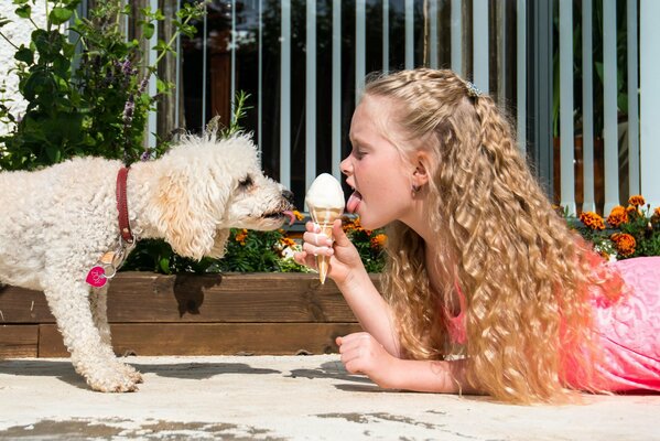 Niña con perro comiendo helado