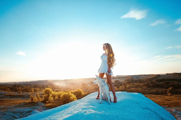 A girl with a dog on the background of a yellow forest
