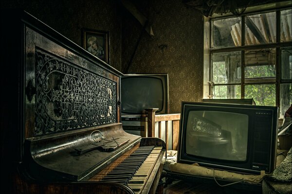 Una habitación oscura en una casa abandonada, con un piano polvoriento y televisores viejos