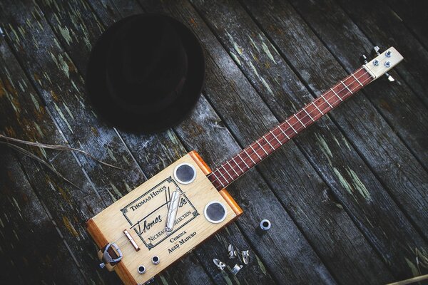 Guitarra y sombrero en el viejo piso de madera