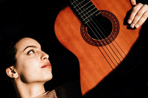 The girl is holding a guitar in her hands