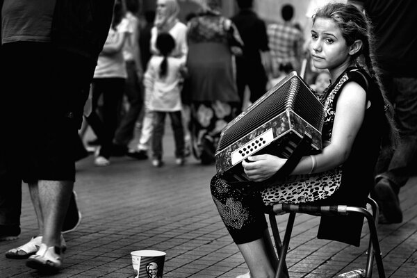 Chica con coletas tocando la armonía para los transeúntes