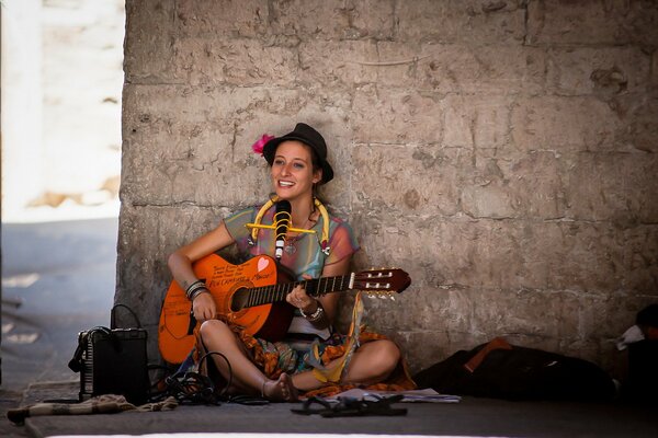 Ragazza con la chitarra al muro