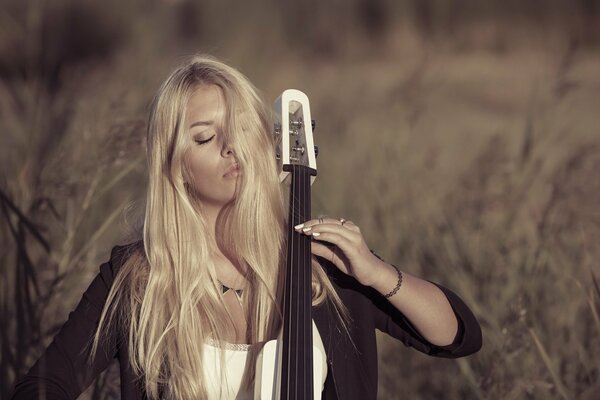 A girl in nature plays an instrument