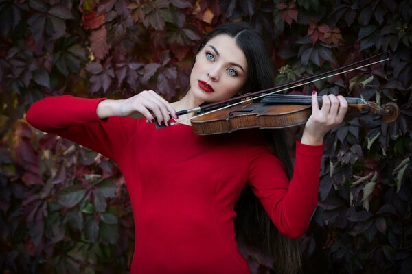 A girl in red with a violin. Autumn time