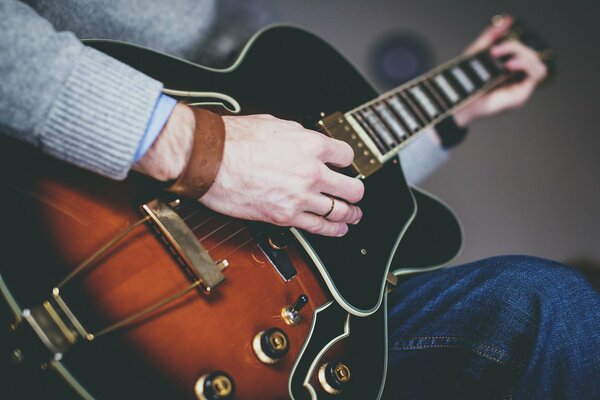 Un hombre toca un instrumento musical, la guitarra