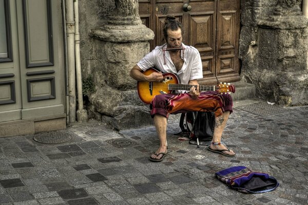 Músico callejero tocando sentado en una silla