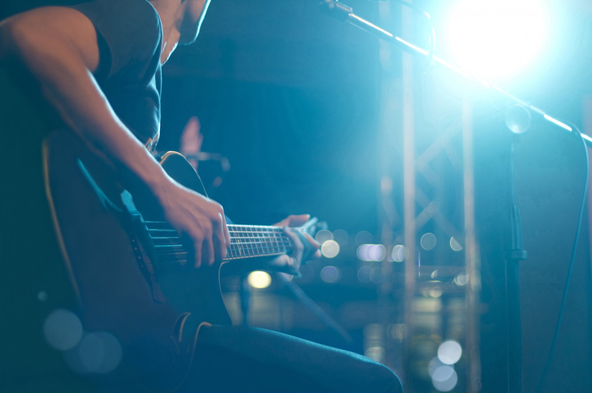 musical instrument gitarre sechssaitig saiten bünde musiker spielt lebendig ton konzert bühne halle mehrfarbig lichter musik unschärfe bokeh tapete