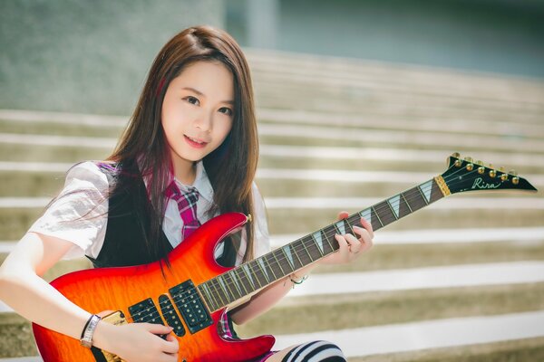 Beautiful Asian girl with guitar