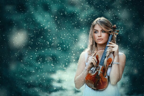 Chica con violín en medio de la nieve