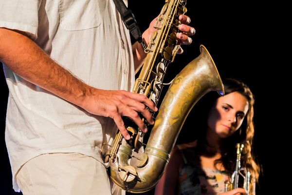 Musikerin guckt hinter dem Saxophon her