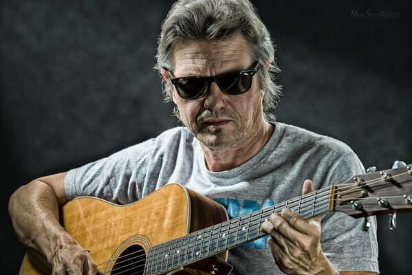 Jerry Wall trägt schwarze Brille mit Gitarre