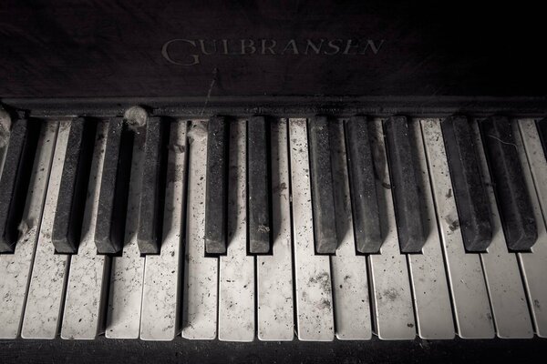 Les touches du vieux piano Gulbransen dans la poussière