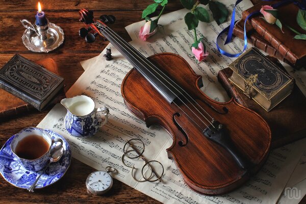 Naturaleza muerta: gafas, libros, violín, vela