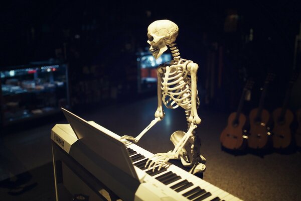 Skeleton plays synthesizer in the studio