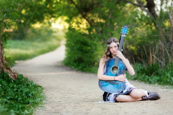 Guitarra azul en las manos de una morena