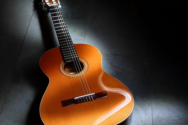 The bend of a yellow guitar on a gray background