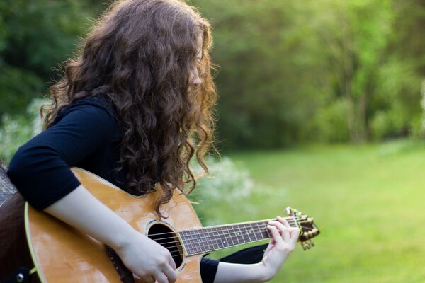 Ragazza sul campo con la chitarra in mano