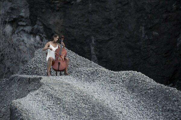 Juego de violonchelo chica en las montañas