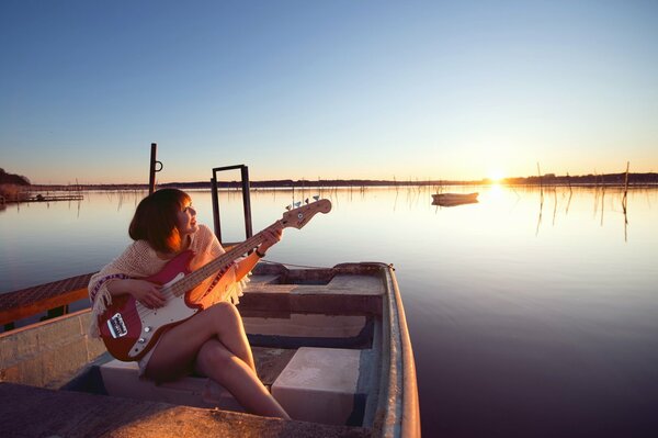 Ragazza con chitarra in barca