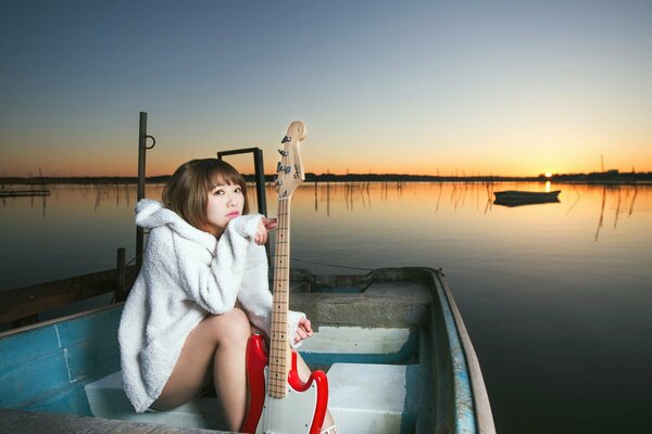 Lonely girl with a guitar on a boat