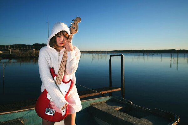 Ragazza con chitarra su una barca