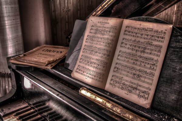 Old black piano with sheet music