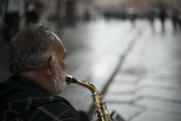 A man plays a saxophone on the street