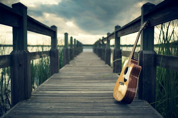 Guitarra en el muelle bajo el cielo nublado