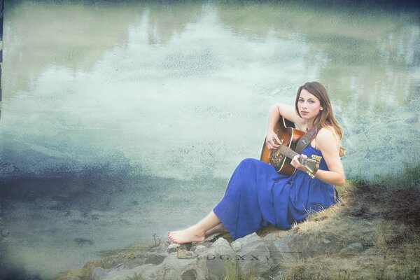 Fille avec une guitare sur la rive de la rivière