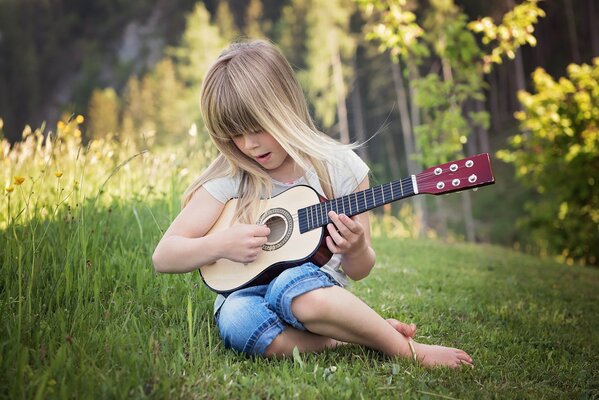 A girl plays the guitar in nature