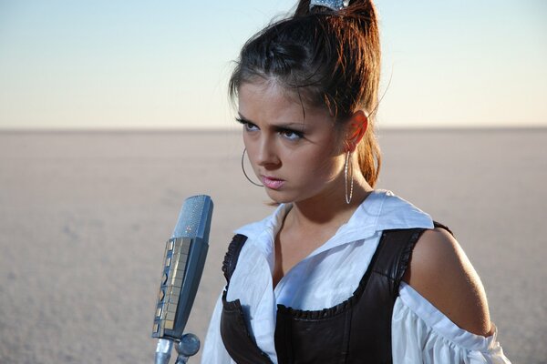 Singer Nyusha with a Microphone in the desert