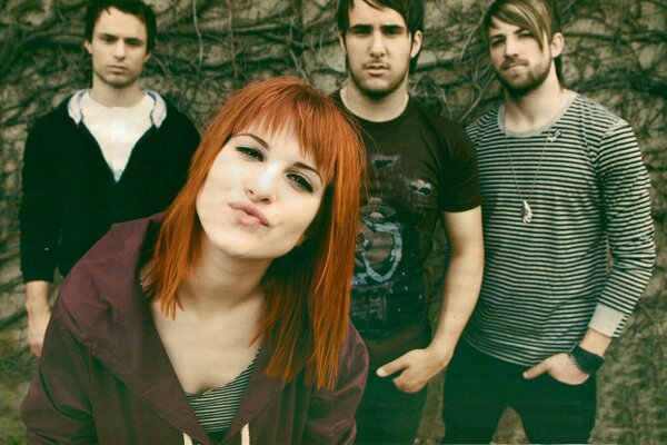 Groupe de Rock de quatre personnes avec une fille Rousse