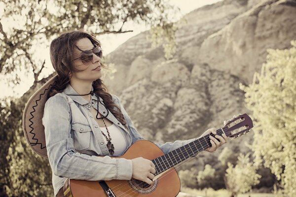 Melancólica chica tocando la guitarra