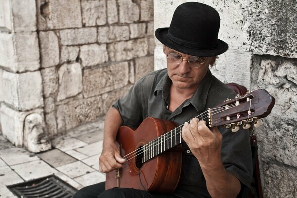 Sombrero gafas hombre guitarra en las escaleras