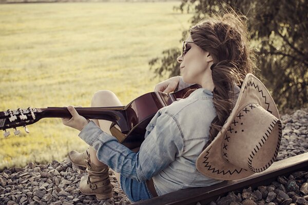 Mädchen mit Hut spielt Gitarre