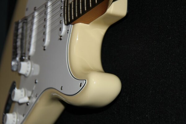 A milky guitar on a black background