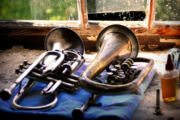 Musical instruments lie on a piece of cloth on an old windowsill