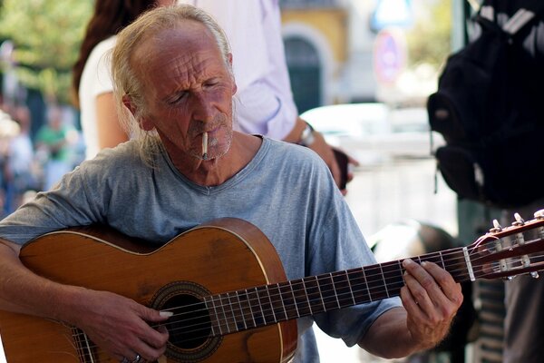 A street musician plays the guitar