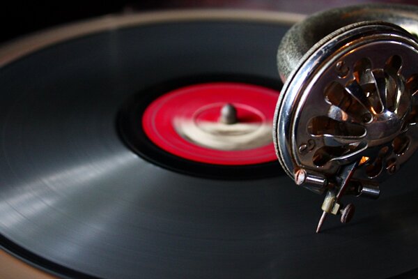 Una aguja de gramófono se coloca sobre un disco de vinilo con una etiqueta roja