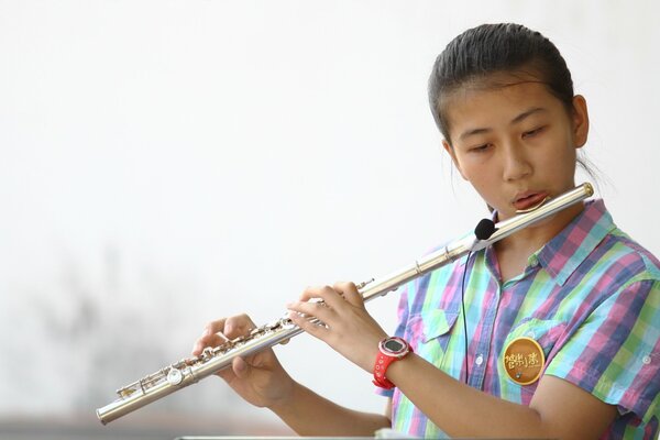 Chica asiática tocando la flauta