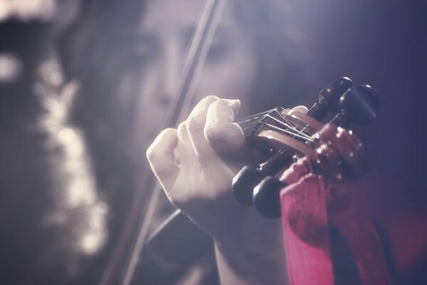 A girl plays the violin in a blurry background