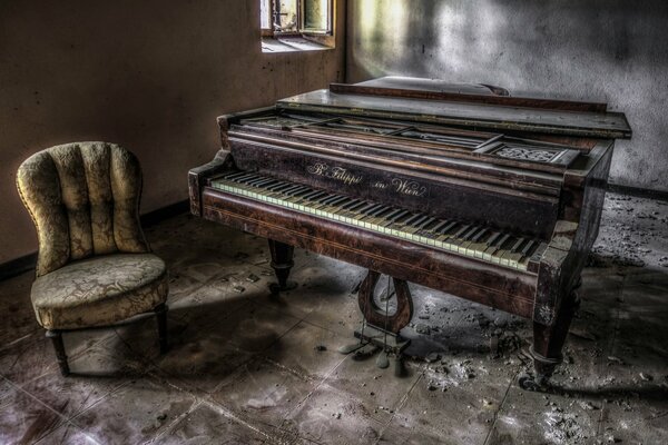 Una silla y un piano antiguo en una casa abandonada