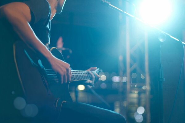 El músico toca la guitarra de seis cuerdas