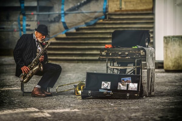 A street musician plays the saxophone