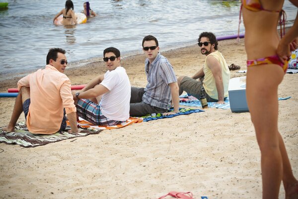 Les hommes regardent la jeune fille en bikini